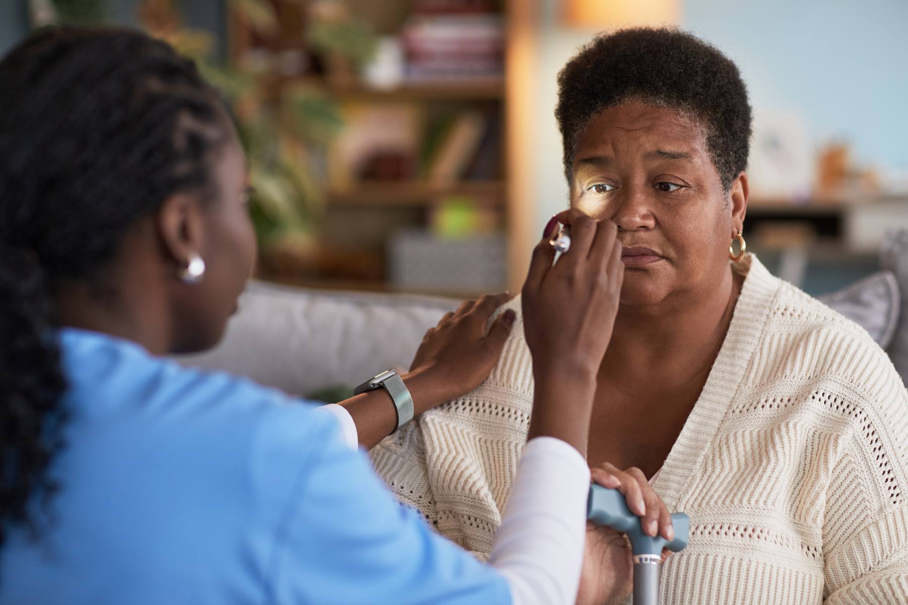 Nurse examining a client at home